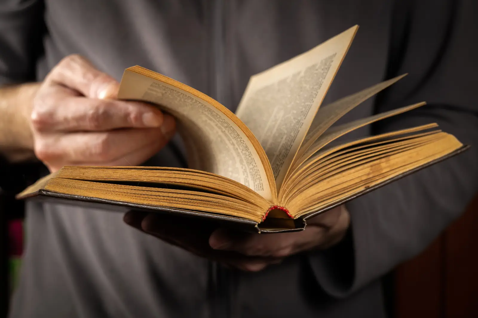 Un expert en livre ancien feuilletant un vieux livre