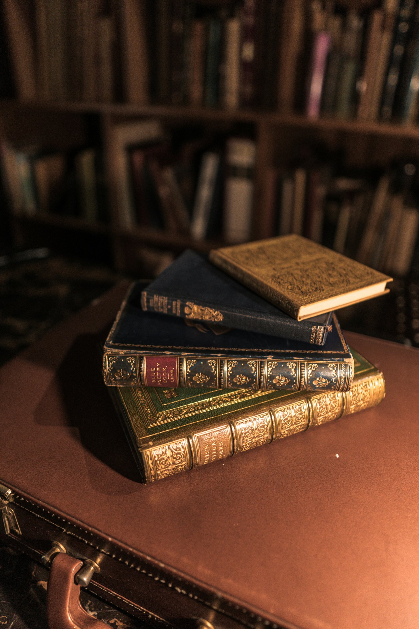Pile de livres anciens relies en cuir avec dorures, poses sur un bureau en cuir - comment savoir si mon livre a de la valeur